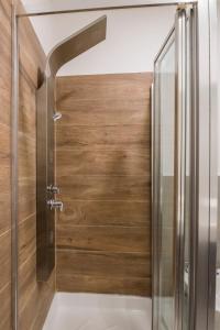 y baño con ducha y puerta de madera. en Hotel Bel Posto by Tandem, en Realicó