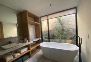 un bagno con una grande vasca e una grande finestra di Desnivel a Valle de Bravo Altre 6 foto