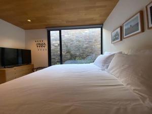 un grande letto bianco in una camera da letto con una grande finestra di Desnivel a Valle de Bravo