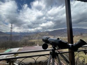 a bike parked on a balcony with a telescope at Aghdepat Hotel in Haghpat