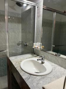 y baño con lavabo y ducha. en Hotel Concorde en Punta del Este