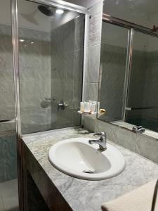 y baño con lavabo y ducha. en Hotel Concorde, en Punta del Este