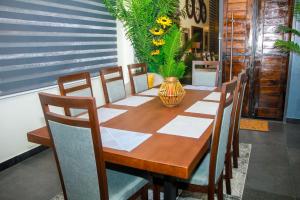 a dining room table with chairs and a vase on it at VIILA LibDo in Cococodji