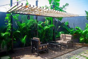un patio con 2 sillas y una pérgola en VIILA LibDo en Cococodji