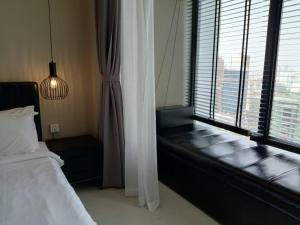 - une chambre avec un lit et une grande fenêtre dans l'établissement De-Luxe Residence, à Phnom Penh