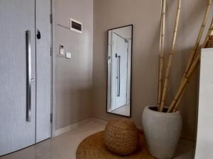 a room with a mirror and a vase with bamboo at De-Luxe Residence in Phnom Penh