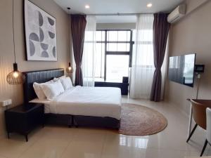 - une chambre avec un lit et une grande fenêtre dans l'établissement De-Luxe Residence, à Phnom Penh
