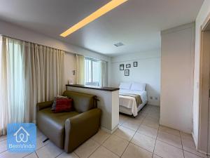 a hotel room with a bed and a chair at Apartamento ao lado do Salvador Shopping 3 in Salvador