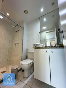 a white bathroom with a toilet and a shower at Apartamento ao lado do Salvador Shopping 3 in Salvador