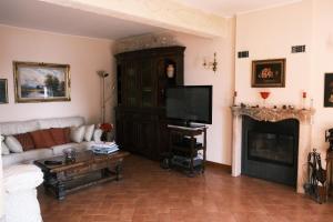a living room with a couch and a tv and a fireplace at L'Alcova tra gli Ulivi by PortofinoVacanze in Zoagli