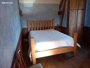 Ce lit en bois se trouve dans un dortoir doté de parquet. dans l'établissement Maison du Bûcheron, à Beaulieu-sur-Dordogne