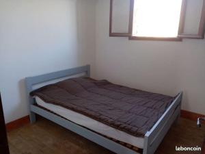 Ce lit se trouve dans une petite chambre dotée d'une fenêtre. dans l'établissement Maison du Bûcheron, à Beaulieu-sur-Dordogne