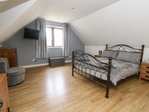 a bedroom with a bed and a couch and a television at Chickerell House in Weymouth