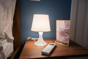 a lamp on a table with a book and a cell phone at Luxury apartment in Naples in Naples +56 photos