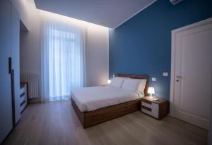 a bedroom with a bed and a blue wall at Luxury apartment in Naples in Naples
