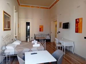 salon z 2 łóżkami i stołem w obiekcie iLCastellano - Suites & Apartments w mieście Lecce