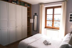 a bedroom with a bed with white cabinets and a window at L'Alcova tra gli Ulivi by PortofinoVacanze in Zoagli