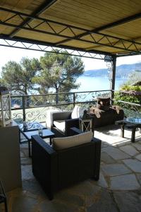 a patio with couches and tables and a view of the ocean at L'Alcova tra gli Ulivi by PortofinoVacanze in Zoagli