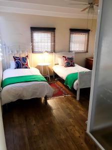 a bedroom with two beds and a table with a lamp at Self Catering Saldanha House in Saldanha