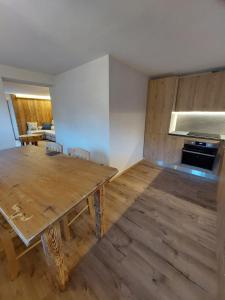 a kitchen with a wooden table in a room at LA POESIA DOLOMITI APARTMENTS in Rivamonte