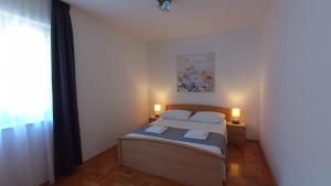 1 dormitorio con 1 cama con 2 lámparas en Apartments Antonio, en Trogir