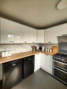 uma cozinha com armários brancos e um fogão em Haydon Hill House em Buckinghamshire