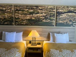 2 camas en una habitación de hotel con un cuadro en la pared en Days Inn by Wyndham Fort Wayne, en Fort Wayne