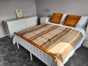 a bedroom with a large bed with orange pillows at Haydon Hill House in Buckinghamshire