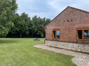 uma casa de tijolos com uma parede de pedra e um quintal em The Annexe em Beeston