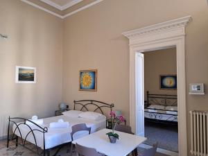 a room with two beds and a table and chairs at iLCastellano - Suites & Apartments in Lecce