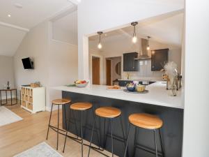 a kitchen with wooden stools and a counter top at Medlands in Newent