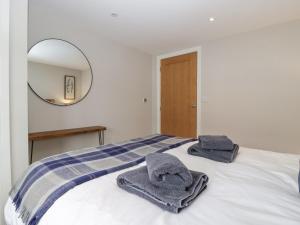 a bedroom with towels on a bed with a mirror at Medlands in Newent