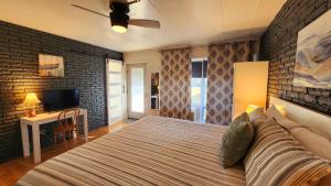 1 dormitorio con 1 cama grande y pared de ladrillo en Watercolors Retreat on Crooked Lake, en Conway