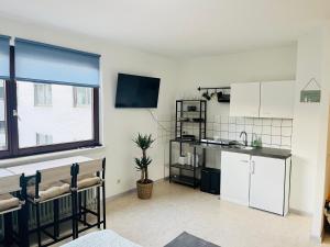 a kitchen with white cabinets and a large window at LENASTAY I Modernes Apartment-Studio near Uni in Kaiserslautern