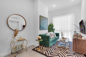 a living room with a green couch and a mirror at Miami Magic Vibrant 2 Bedroom with Free Parking in Miami