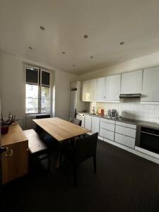 Il comprend une cuisine avec une table et des chaises en bois. dans l'établissement Appartement Eaux Vives The Happy Place Lake Side, à Genève