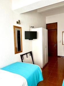 um quarto com uma cama e uma televisão na parede em Hotel Concorde em Punta del Este
