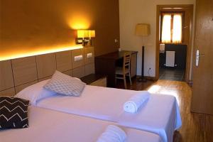 Schlafzimmer mit einem großen weißen Bett und einem Schreibtisch in der Unterkunft Hotel valle de turtzioz in Trucios-Turtzioz