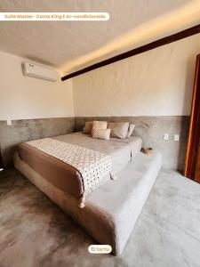 ein Schlafzimmer mit einem großen Bett in einem Zimmer in der Unterkunft Casinha da Vila Taíba com piscina in Taíba
