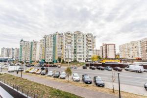 a street with cars parked in front of tall buildings at Vas’ apartment in Chişinău