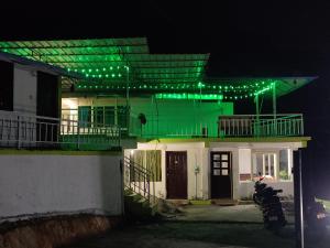 une maison avec des lumières vertes au-dessus dans l'établissement Jungle valley Munnar, à Munnar