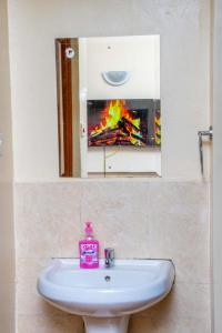 a sink in a bathroom with a fire in the mirror at AirBnB in Nairobi