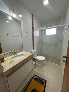 a bathroom with a sink and a toilet and a shower at Apto Apólo - 3 dorm Wifi in São Carlos