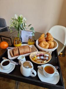 - une table avec des tasses de thé et des pâtisseries dans l'établissement Château de Bayssan, à Béziers