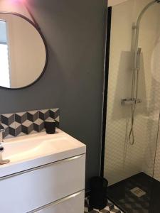 a bathroom with a sink and a shower with a mirror at Maison cosy à 300m de la plage avec spa in Plouescat