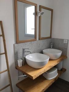 a bathroom with two sinks on a wooden shelf at Maison cosy à 300m de la plage avec spa in Plouescat +17 photos