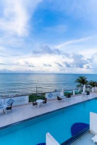 a swimming pool with a view of the ocean at La Suite Praia Hotel in Caucaia