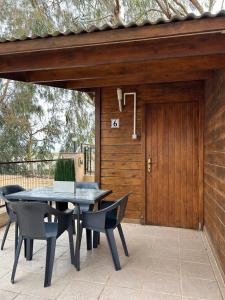 patio con mesa, sillas y puerta de madera en CAMPING DELTA NATURA LA TANCADA, en Amposta