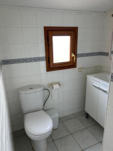baño con aseo blanco y ventana en CAMPING DELTA NATURA LA TANCADA, en Amposta