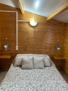 1 dormitorio con 1 cama en una pared de madera en CAMPING DELTA NATURA LA TANCADA, en Amposta